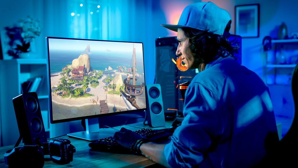 A high-end custom gaming PC with RGB lighting next to a modern gaming desk setup.